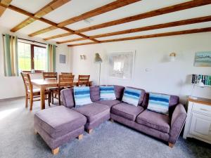 ein Wohnzimmer mit Sofa und Tisch in der Unterkunft Sandpiper Cottage: cosy home near the beach in Woolacombe