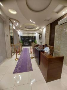 穆哈伊犁اوبرا جولد2的坐在酒店大堂柜台的女人