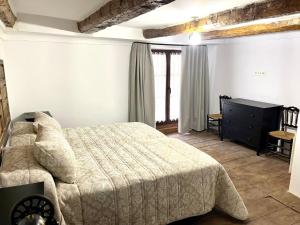 a bedroom with a bed and a dresser in it at La Mirada de Juana in Tordesillas