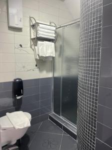 a bathroom with a shower and a toilet with towels at Sienna Residence in Skopje