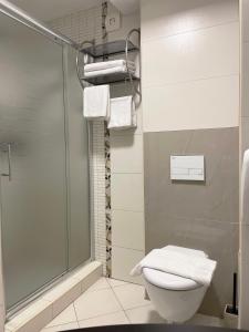 a bathroom with a shower and a toilet and towels at Sienna Residence in Skopje +36 photos