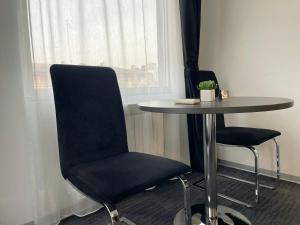 a table and two chairs next to a window at Sienna Apartments in Skopje