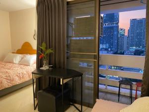 a bedroom with a bed and a view of a city at Patunam Building , Shopping , Airport Rail link in Bangkok
