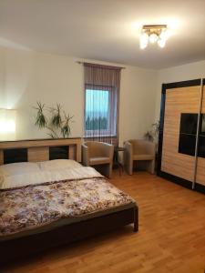 StrykowoにあるDom za Tujamiのベッドルーム(ベッド1台、椅子付)