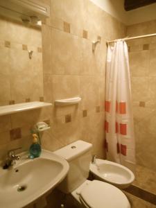Un baño con un inodoro blanco y un lavabo. en Familia Tejada, en Mendoza