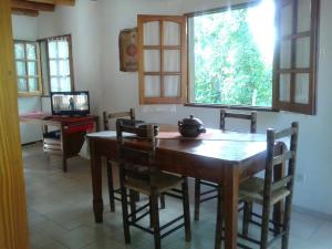 Un comedor con mesa y sillas de madera. en Familia Tejada, en Mendoza