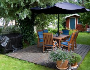 a wooden table and chairs under an umbrella at Trea centralt Västervik in Västervik