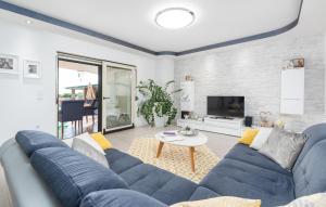 a living room with a blue couch and a tv at Villa St. Anna in Radetići - Haus für 8 Personen in Radetići