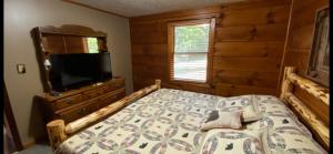 a bedroom with a bed and a dresser and a television at Mountain Laurel in Sevierville
