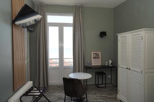 a living room with a table and a window at l'itinerance in Mers-les-Bains