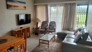 a living room with a couch and a table at The Cabanas in Scottburgh