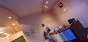 a room with a bed and a desk with a computer at Sofia Family Hotel in Pomorie