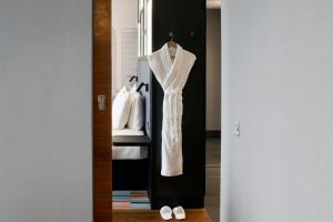 a wardrobe with a white dress and white shoes at Aloft London Excel in London