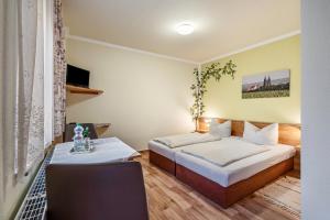 a hotel room with two beds and a table at Pension Ufert in Meißen