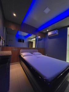 萨尔瓦多Hotel Alfama Motel的一间卧室配有一张蓝色灯床