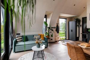 a living room with a green couch and a table at GreenFloat Boskoop #2 in Boskoop