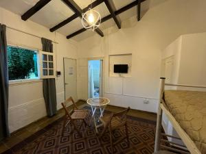 a room with a bed and a table and chairs at Complejo Puertas Rosas in Villa Carlos Paz