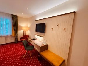 a hotel room with a desk and a chair at Hotel Fliegerheim in Borkheide