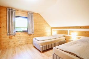 a bedroom with two beds and a window at Modernes Ferienhaus mit Kamin & Garten in ruhiger Lage in Hasselfelde