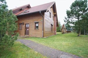 a small wooden house with a grass yard at Modernes Ferienhaus mit Kamin & Garten in ruhiger Lage in Hasselfelde