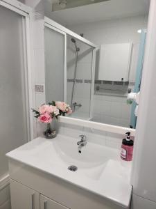 a bathroom with a sink with a mirror and flowers at Hikari&Sineida Home in Rincón de la Victoria