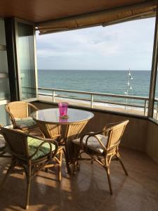 a balcony with a table and chairs and the ocean at Apartamento Rosendo in Calafell