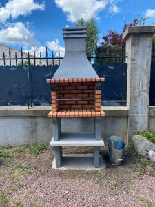 a small brick oven sitting next to a fence at Chambre Nuit d'Asie in Montournais