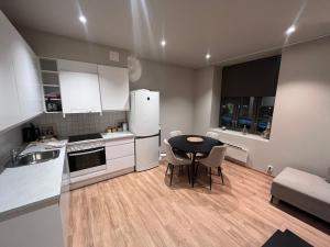 a kitchen with a table and chairs and a kitchen with white appliances at Spacious Retreat in Oslo