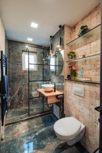a bathroom with a toilet and a glass shower at Ilmar suites - new in Cluj-Napoca