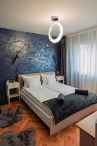 a bedroom with a large bed with a blue wall at Ilmar suites - new in Cluj-Napoca