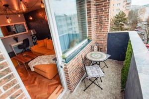 a small balcony with a couch and a table at Ilmar suites - new in Cluj-Napoca
