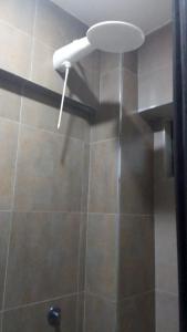 La salle de bains est pourvue d'une douche avec un pommeau de douche blanc. dans l'établissement A Fully Budget premium Studio, à Nairobi 10 autres photos