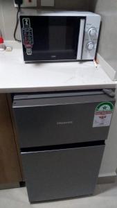 Un four micro-ondes est installé au-dessus d'un réfrigérateur. dans l'établissement A Fully Budget premium Studio, à Nairobi