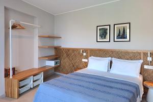 a bedroom with a large bed with a blue blanket at Kechria Bay Villas in Skiathos +21 photos