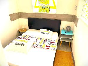 een kleine slaapkamer met 2 bedden en verjaardagskussens bij LES BUNGALOWS DE LOUISIANE in Saint-François