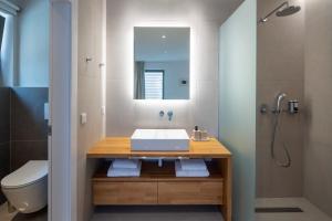 a bathroom with a sink and a toilet and a mirror at Kechria Bay Villas in Skiathos