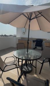 a table and chairs with an umbrella on a balcony at Suite For You - Salinas Chipipe in Salinas