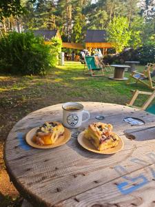 a wooden table with two pastries and a cup of coffee at Przystań Osiek in Osiek