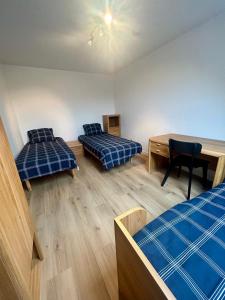 a room with two beds and a desk in it at La Sabbia in Oostduinkerke