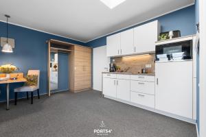 a kitchen with white cabinets and a blue wall at Ferienwohnung Bude 5 Dagebüll in Dagebüll