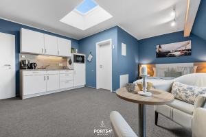 a living room with blue walls and a couch and a table at Ferienwohnung Bude 5 Dagebüll in Dagebüll +23 photos
