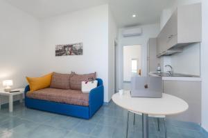 a living room with a blue couch and a table at Residence Pietre Bianche ApartHotel in Pizzo