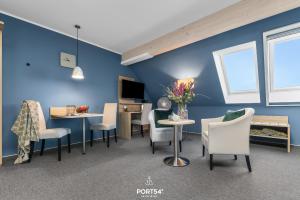 a living room with blue walls and tables and chairs at Ferienwohnung Bude 6 Dagebüll in Dagebüll