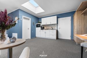 a kitchen with white cabinets and a blue wall at Ferienwohnung Bude 6 Dagebüll in Dagebüll +23 photos