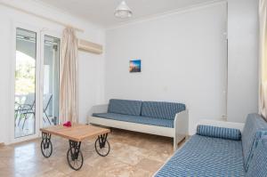 a living room with two blue couches and a table at Markella Maisonette Hotel Complex in Marathias