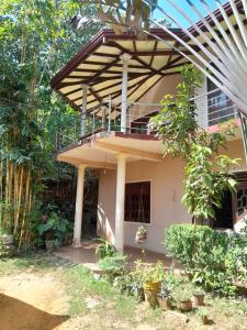 a house with a balcony on top of it at sisi place in Dickwella