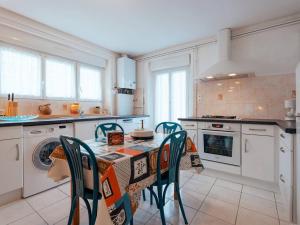 eine Küche mit einem Tisch und Stühlen darin in der Unterkunft Appartement 3P 69m² à mi-chemin plage et bourg de Carnac - FR-1-477-130 in Carnac