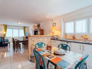カルナックにあるAppartement 3P 69m² à mi-chemin plage et bourg de Carnac - FR-1-477-130のテーブルと椅子のあるキッチンとダイニングルーム +2枚の写真