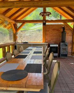 a large wooden table and chairs in a pavilion at Cabana Izvorul Rece Maramureş in Baia-Sprie