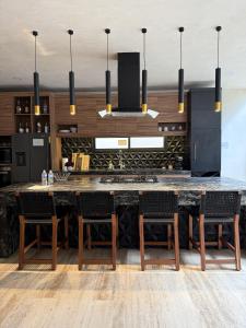 a kitchen with a large kitchen island with chairs at Villa Escondida - Riviera Maya in Puerto Morelos